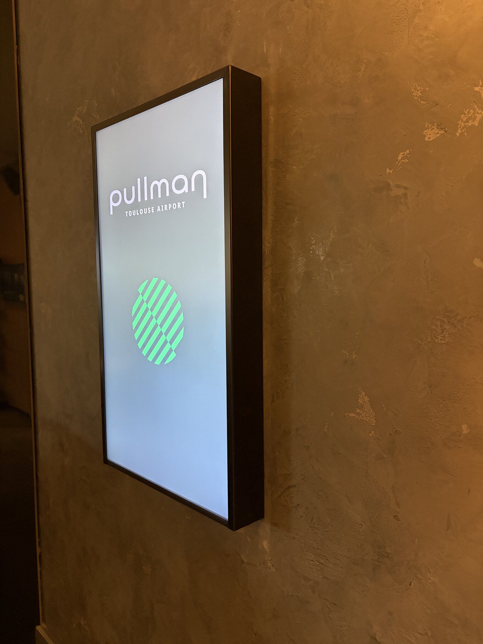 Pullman Toulouse Airport : écran portrait encadré, posé en signalétique murale.