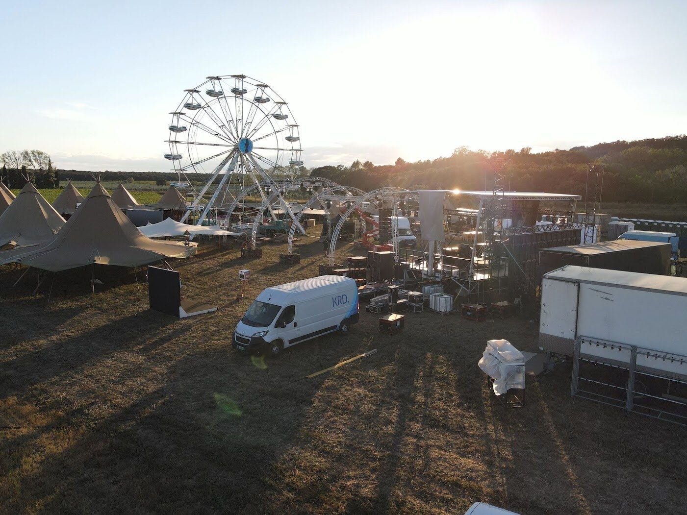 Montage sur un site de festival : scène, arches de structure et parc technique livrés avant l’ouverture au public.