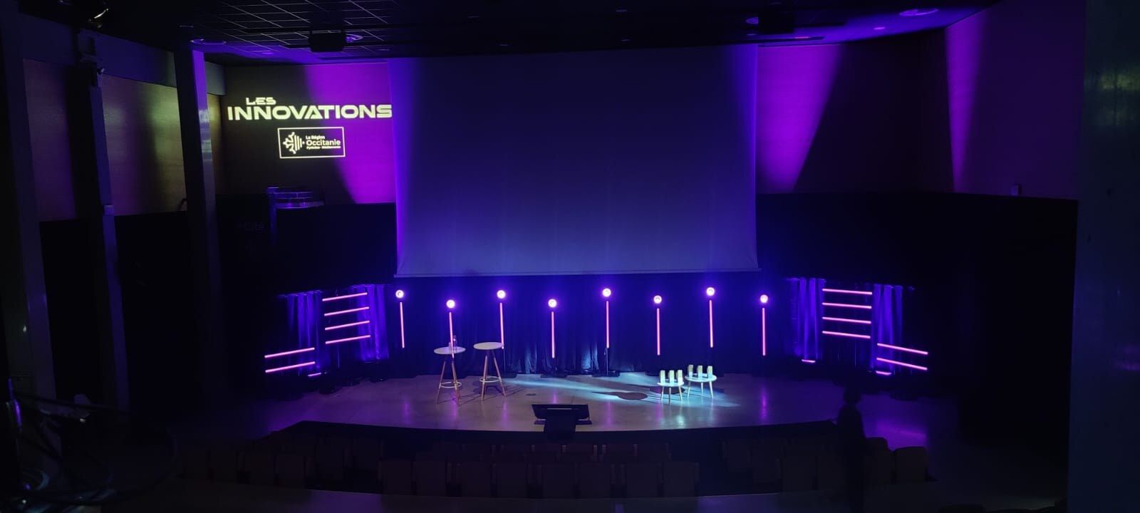 Les Innovations, région Occitanie : décor de tubes LED, écran de projection et plateau de conférence.