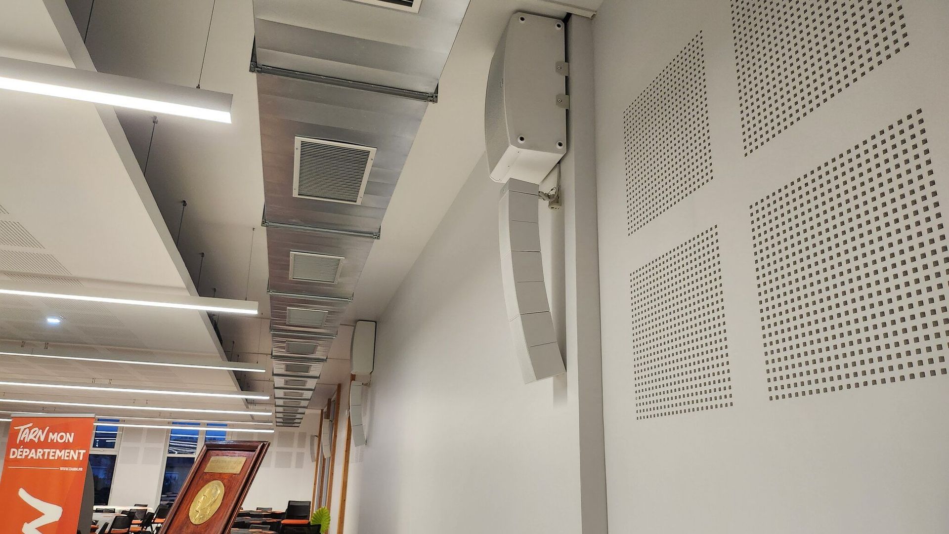 Enceinte de diffusion intégrée à l’architecture d’un hall d’accueil.